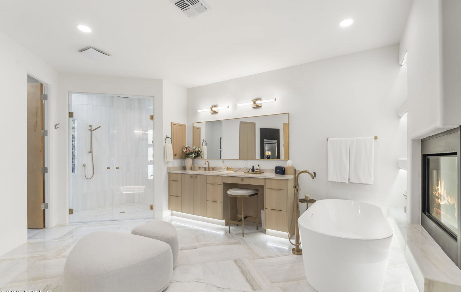 Walk-in marble shower with dual vanities beyond