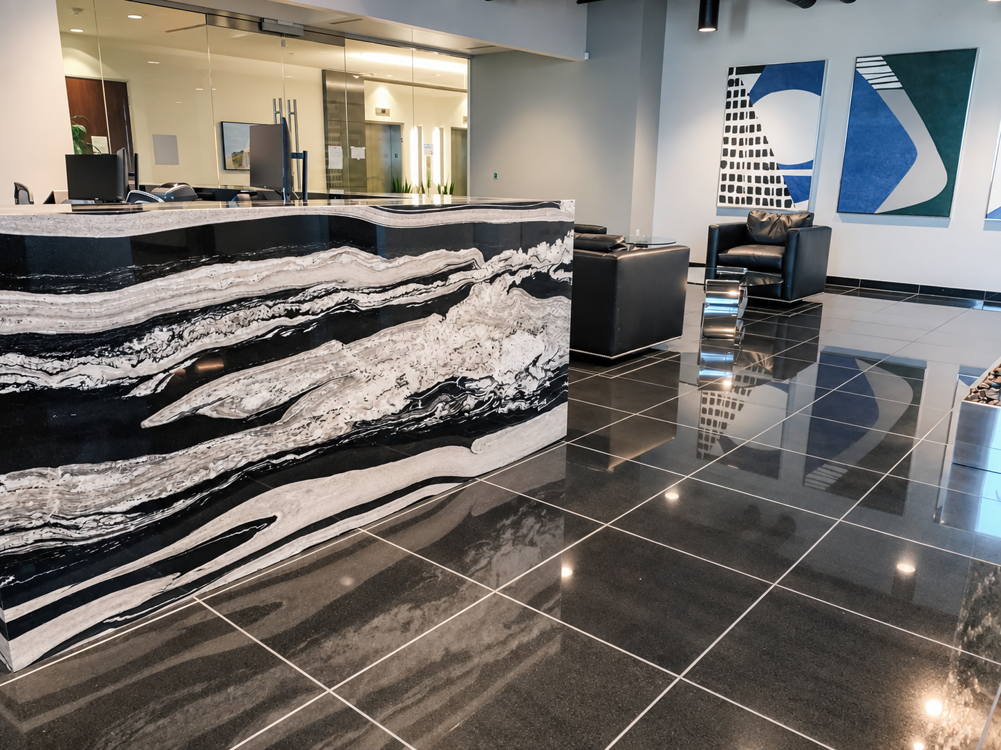 Commercial lobby with a dramatic marble reception desk and polished tile floors