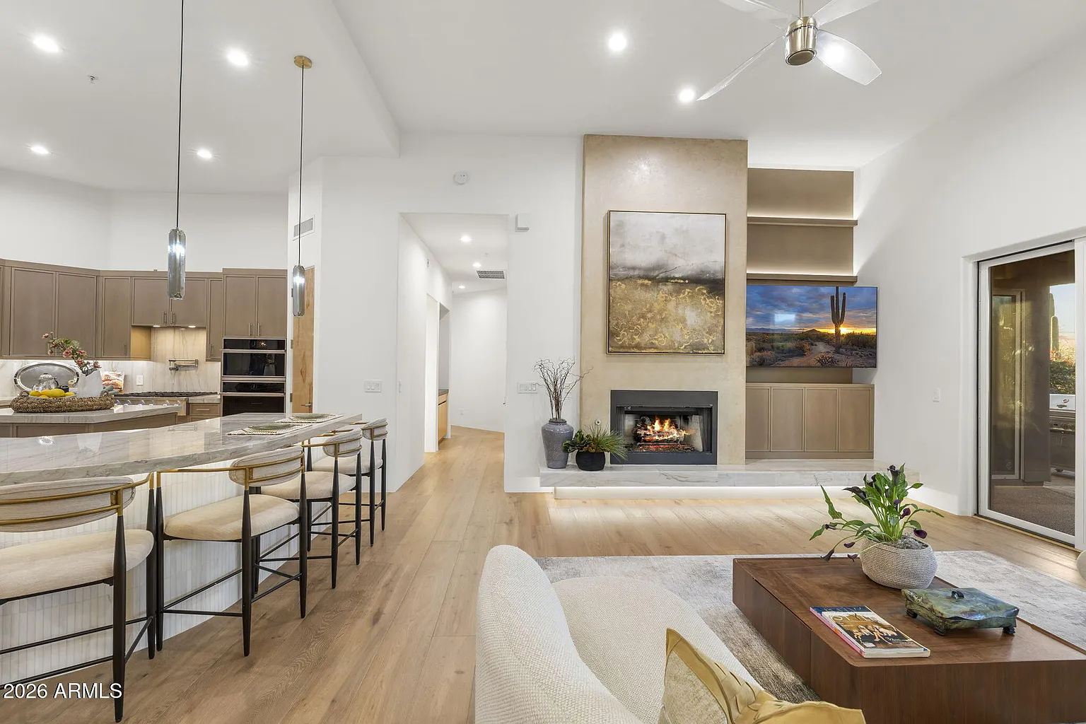 Open kitchen and living area with quartzite island, custom cabinetry, and desert views