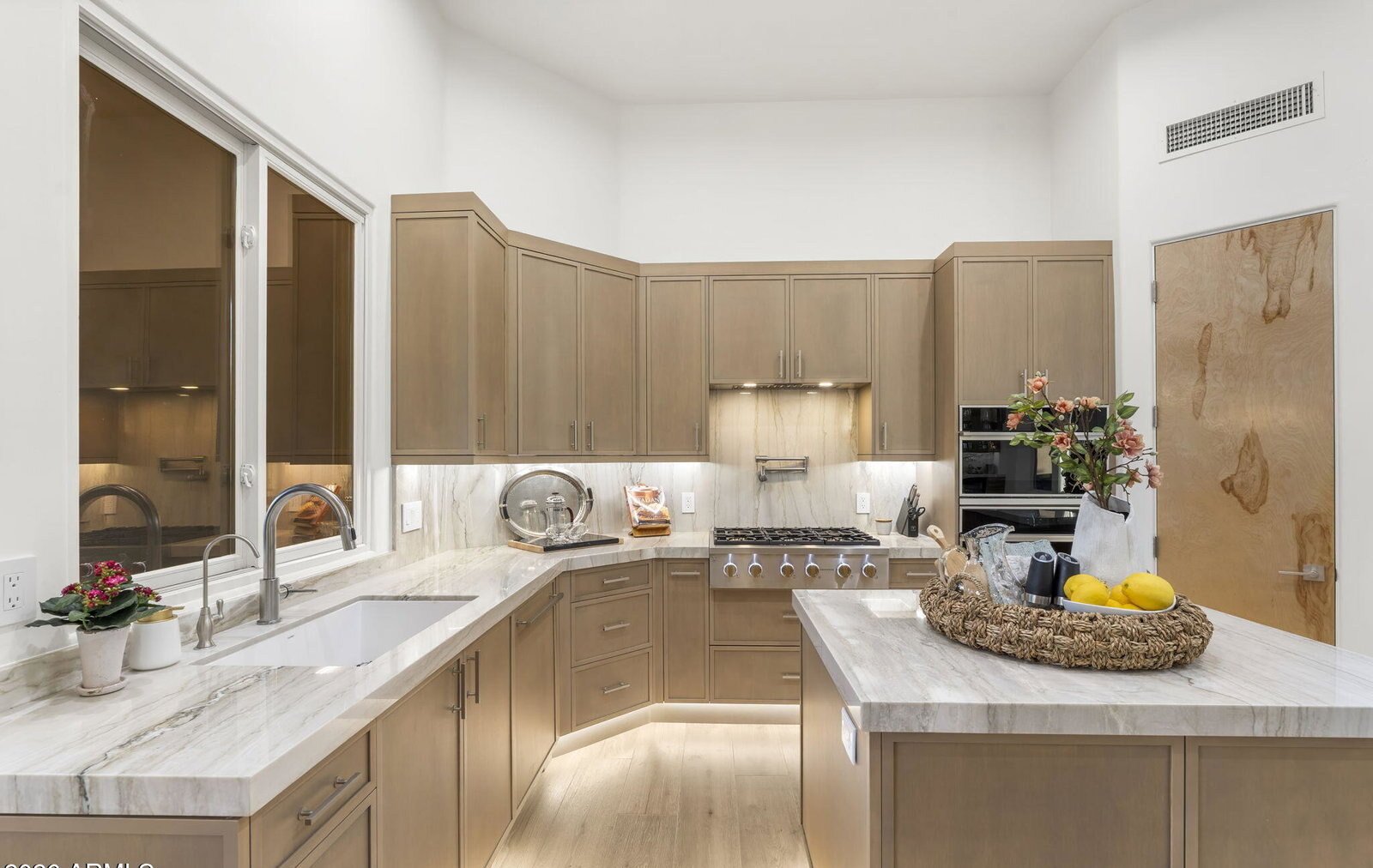 Chef's kitchen with quartzite island, custom oak cabinetry, and pendant lights