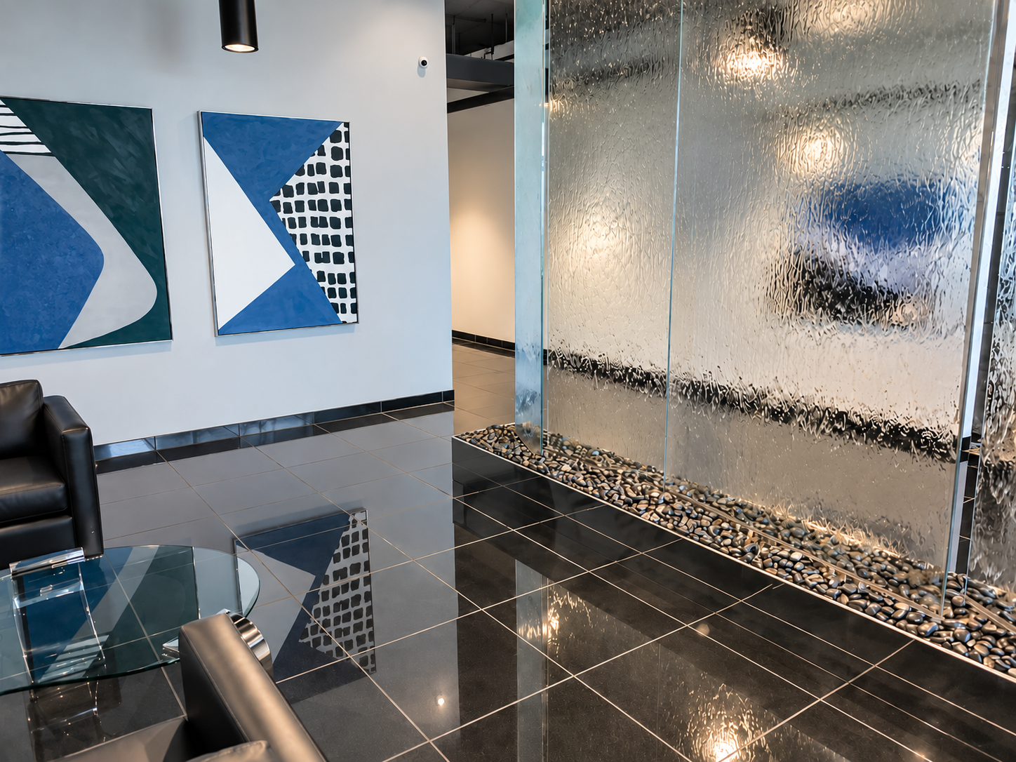 Commercial lobby with a textured glass water feature and polished black tile