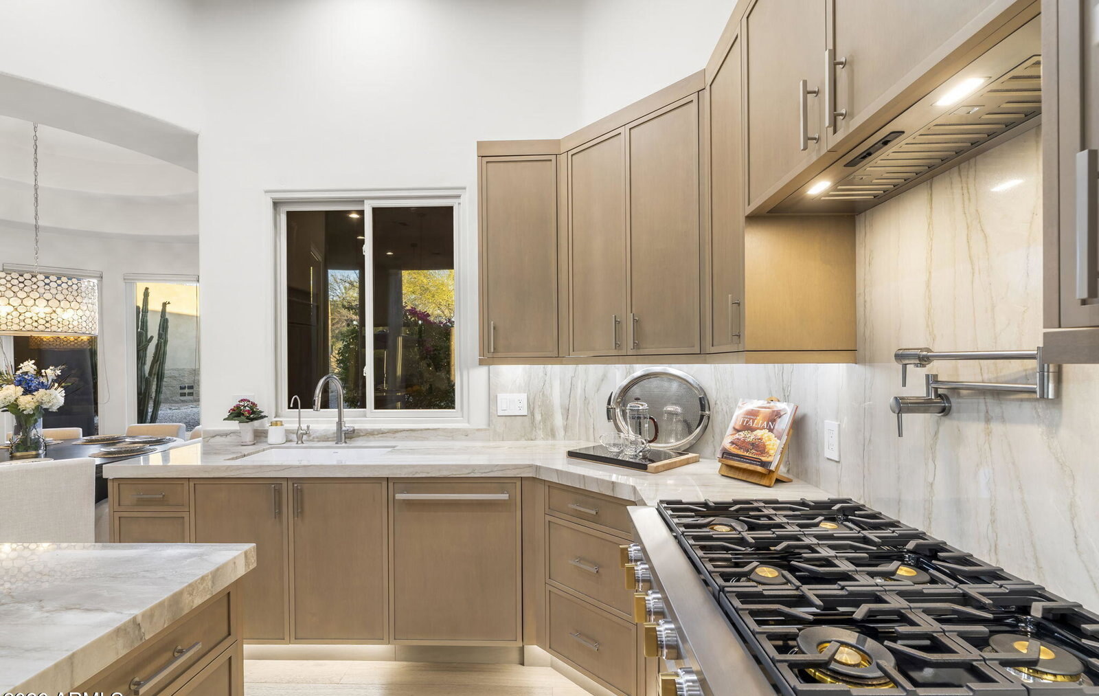 Six-burner Monogram gas range with custom hood and oak cabinetry